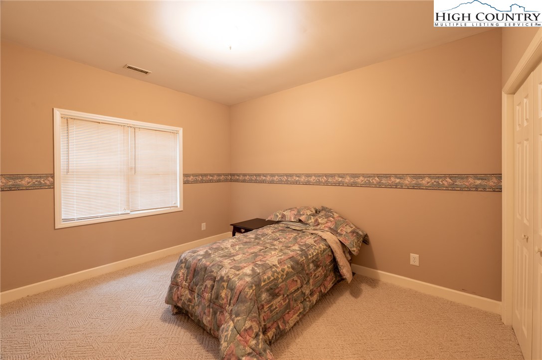 130 Prudden Lane, Unit 103 Blowing Rock, NC 28605 - Photo 19 of 36 a bed sitting in a bedroom next to a window