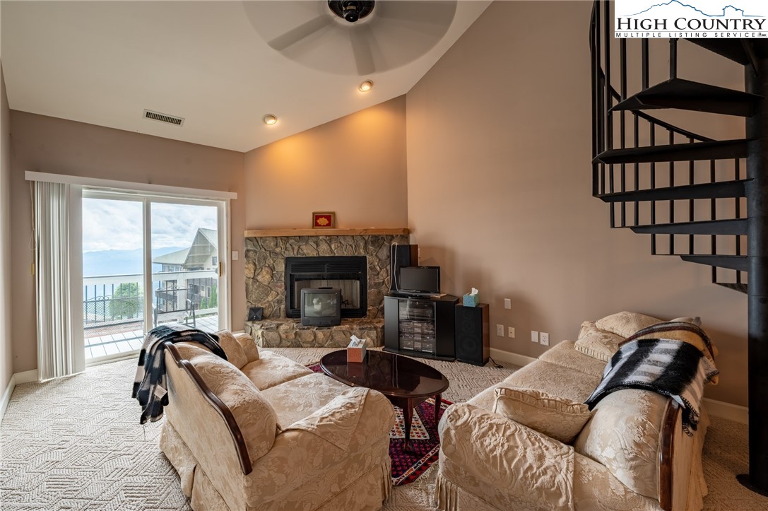 130 Prudden Lane, Unit 103 Blowing Rock, NC 28605 - Photo 28 of 36 a living room with furniture a fireplace and a floor to ceiling window