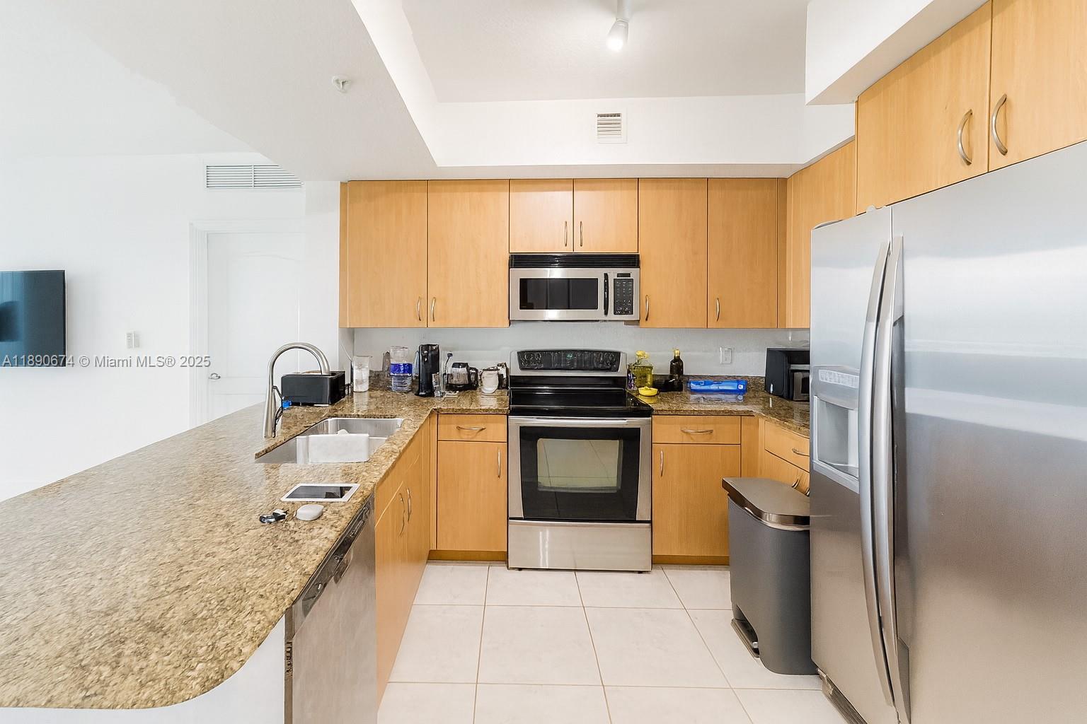 a kitchen with stainless steel appliances granite countertop a refrigerator sink and stove