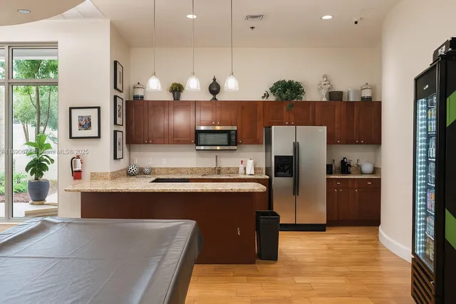 a kitchen with stainless steel appliances granite countertop a refrigerator and a stove top oven