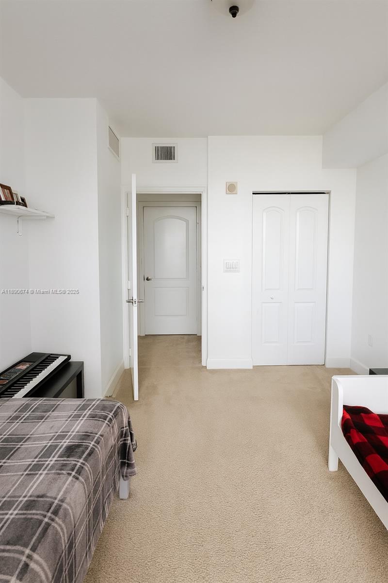 1830 Radius Drive, Unit 308 Hollywood, FL 33020 - Photo 7 of 31 a bedroom with a bed and a cabinets