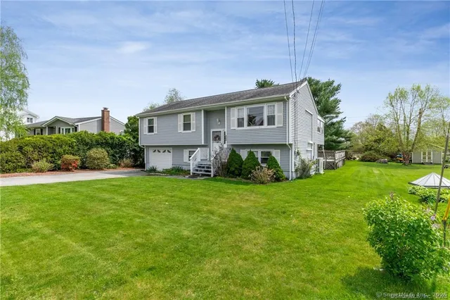 a front view of a house with a yard and trees