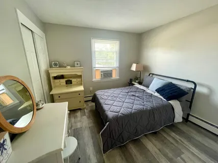 a bedroom with a bed and wooden floor