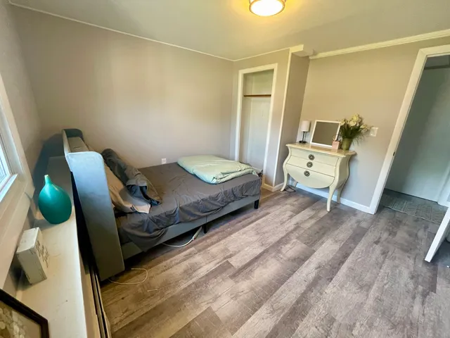 a bedroom with a bed and wooden floor