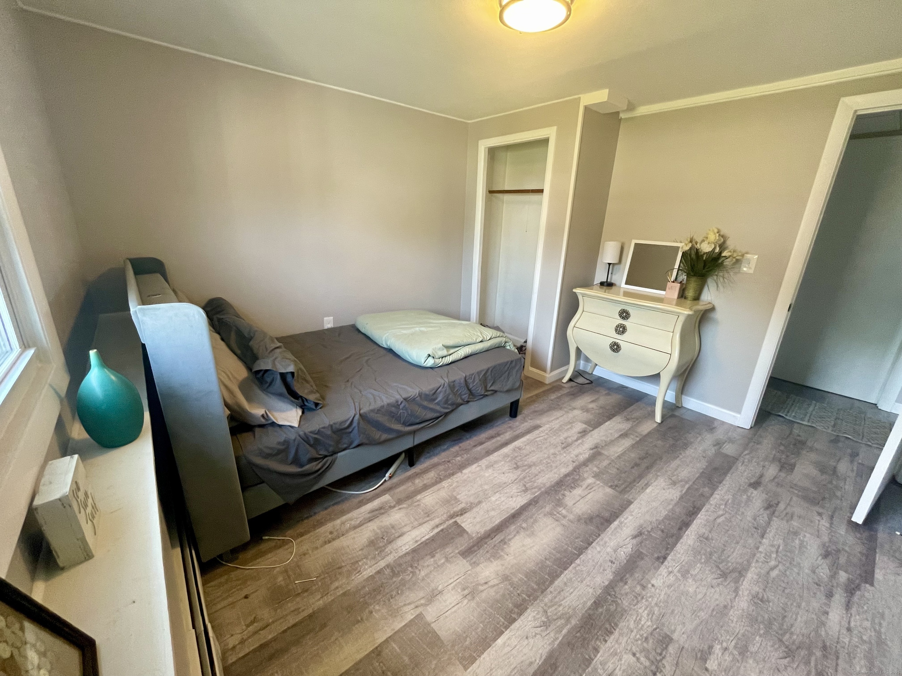 223 Seneca Drive Groton, CT 06340 - Photo 21 of 27 a bedroom with a bed and wooden floor