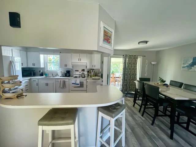 a kitchen with a dining table chairs and white cabinets