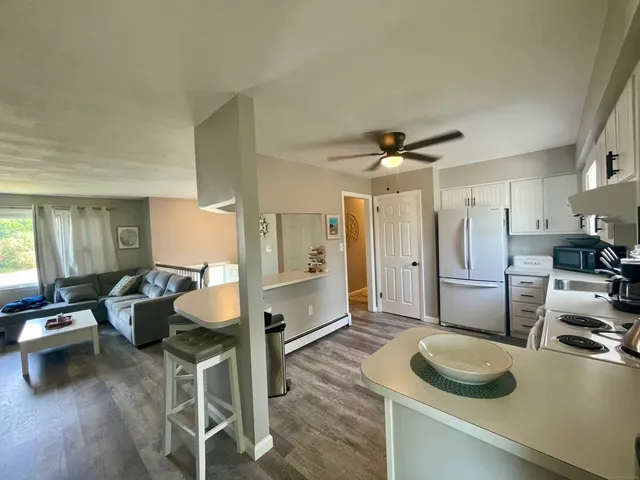 a kitchen with stainless steel appliances granite countertop a sink a stove and a refrigerator