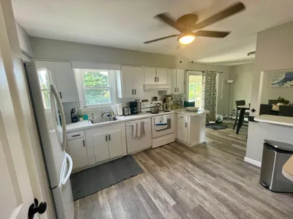a kitchen with cabinets a sink a window and stainless steel appliances