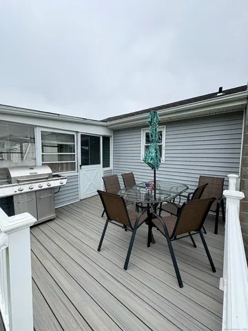 a view of a roof deck with table and chairs couches with wooden floor