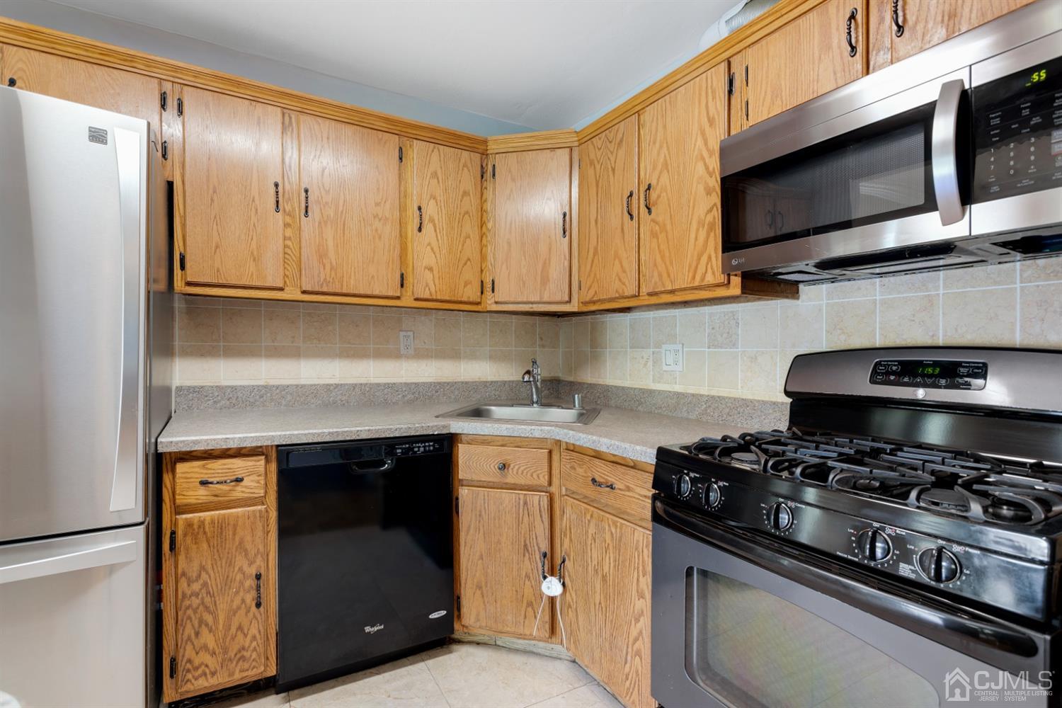 28 Arrowsmith Court Old Bridge, NJ 07747 - Photo 8 of 30 a kitchen with stainless steel appliances a sink a stove and cabinets
