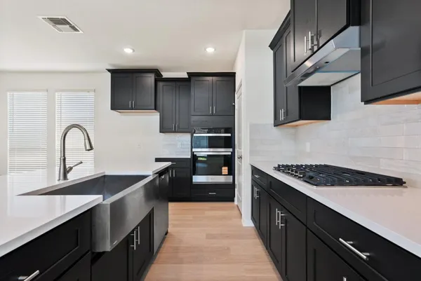 a view of kitchen with stove top oven and cabinets