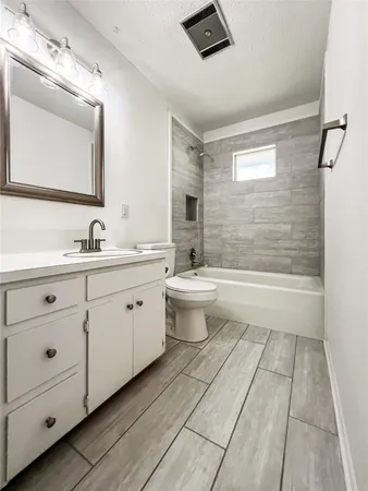 a bathroom with a double vanity sink toilet mirror and bathtub