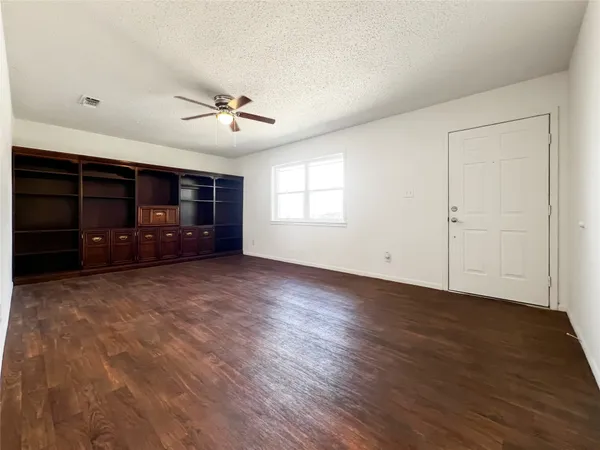wooden floor in an empty room with a ceiling fan
