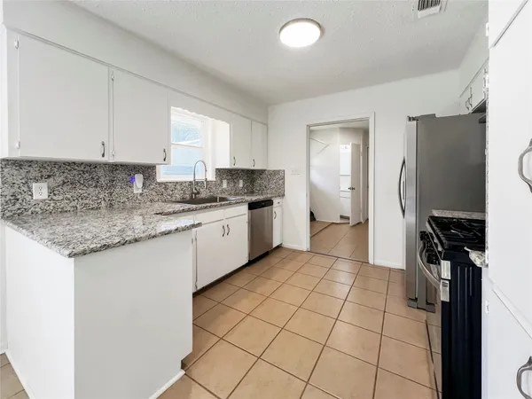 a kitchen with a sink a refrigerator and cabinets