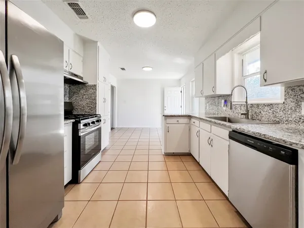 a kitchen with stainless steel appliances granite countertop a refrigerator sink and cabinets