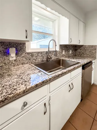 a kitchen with granite countertop a sink and cabinets