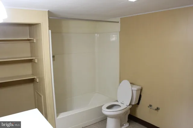 a bathroom with a toilet and a shower