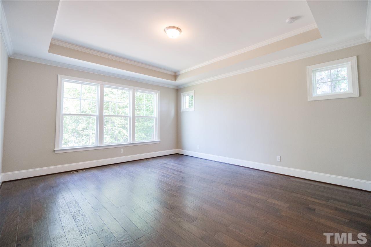 520 Adkins Ridge Road Rolesville, NC 27571 - Photo 13 of 25 an empty room with wooden floor and windows