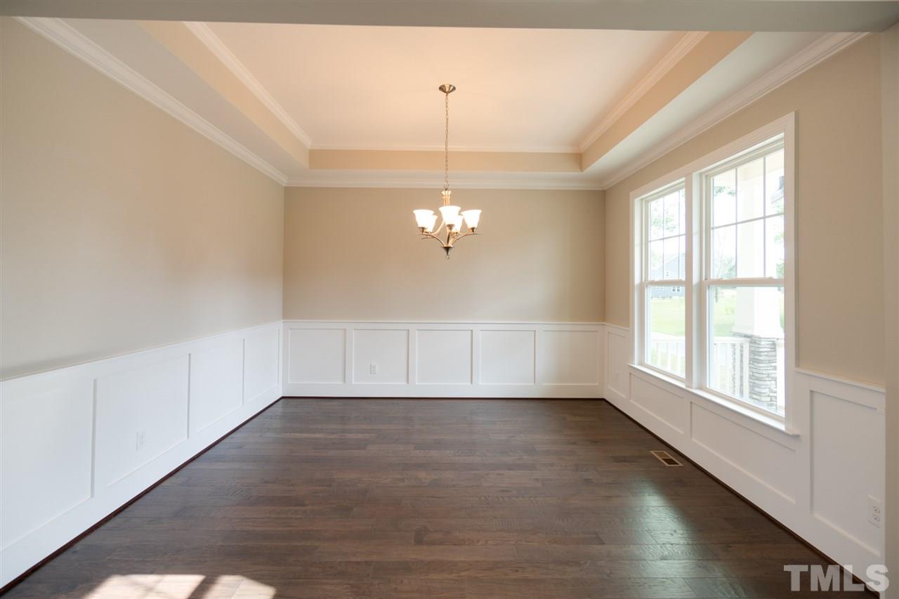 520 Adkins Ridge Road Rolesville, NC 27571 - Photo 3 of 25 an empty room with wooden floor chandelier fan and windows