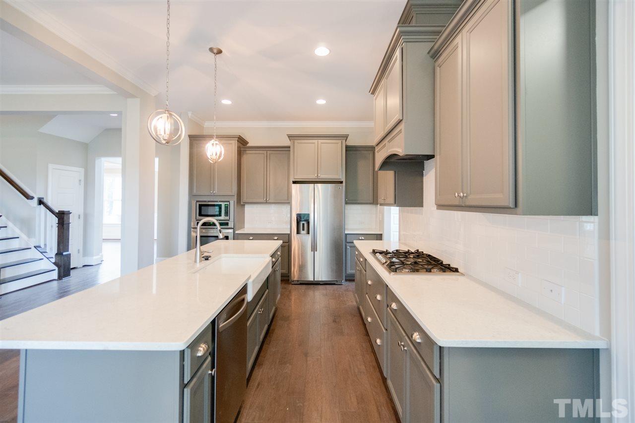 520 Adkins Ridge Road Rolesville, NC 27571 - Photo 7 of 25 a kitchen with kitchen island stainless steel appliances a stove a sink a refrigerator and chairs
