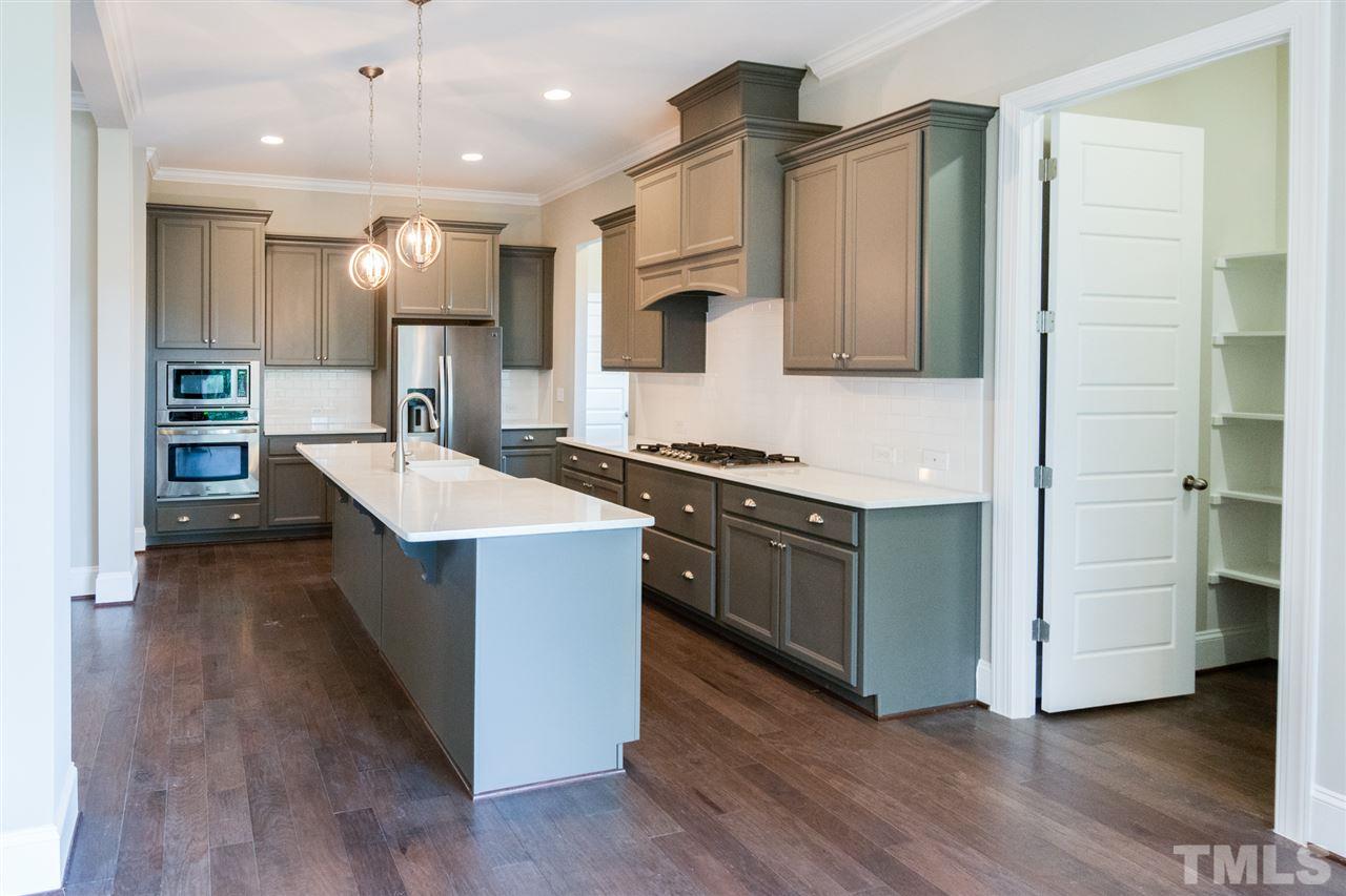 520 Adkins Ridge Road Rolesville, NC 27571 - Photo 8 of 25 a kitchen with stainless steel appliances kitchen island granite countertop a stove a sink and a refrigerator