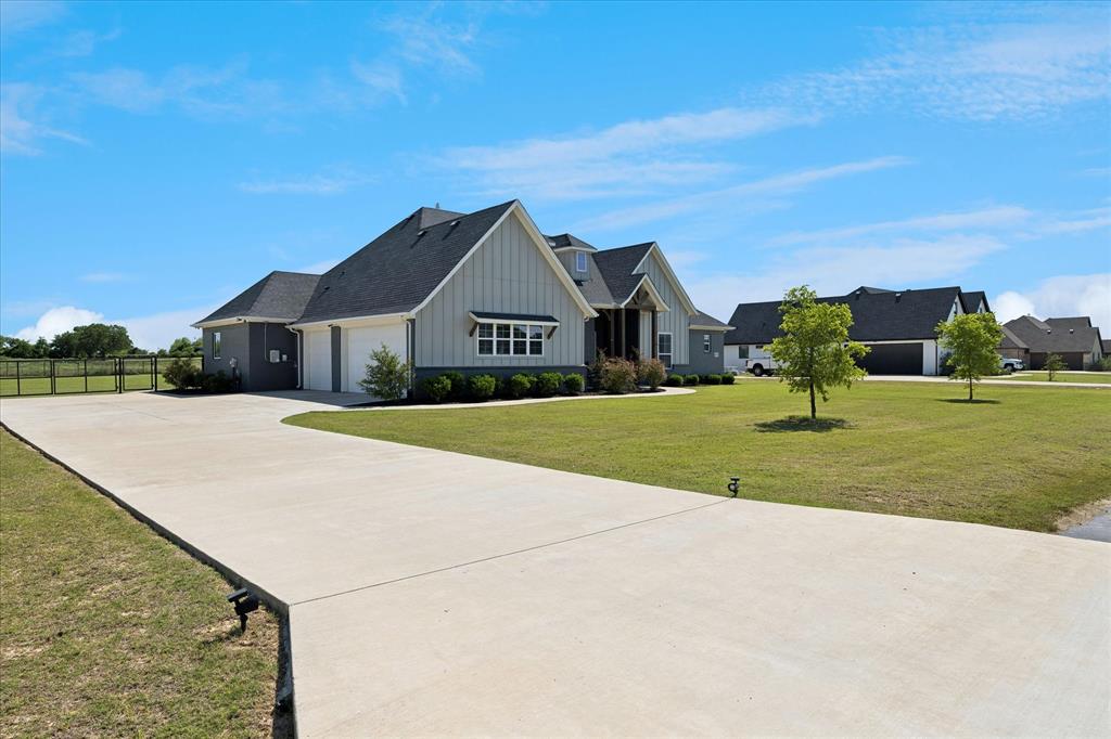 112 Friendship Way Boyd, TX 76023 - Photo 29 of 29 Contemporary farmhouse exterior featuring light gray vertical siding, dark gray horizontal siding, and a dark shingle roof
