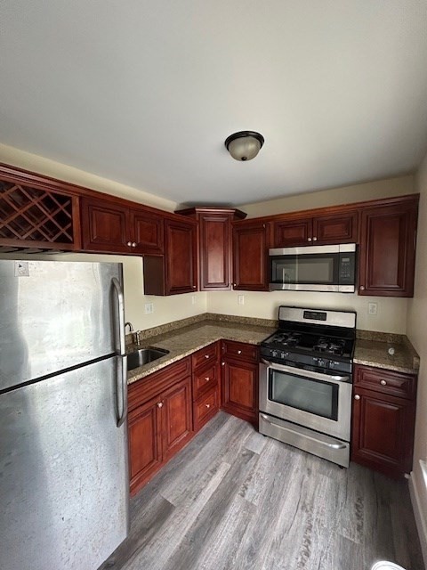 a kitchen with stainless steel appliances granite countertop a stove a sink and a refrigerator
