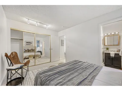 a bedroom with a bed a chair and painting on the wall