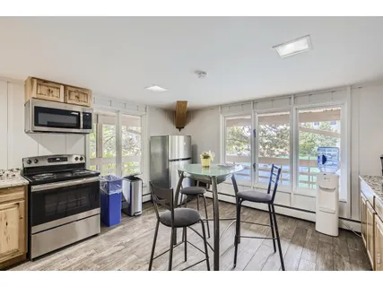 a kitchen with stainless steel appliances kitchen island granite countertop a stove a sink a dining table and chairs