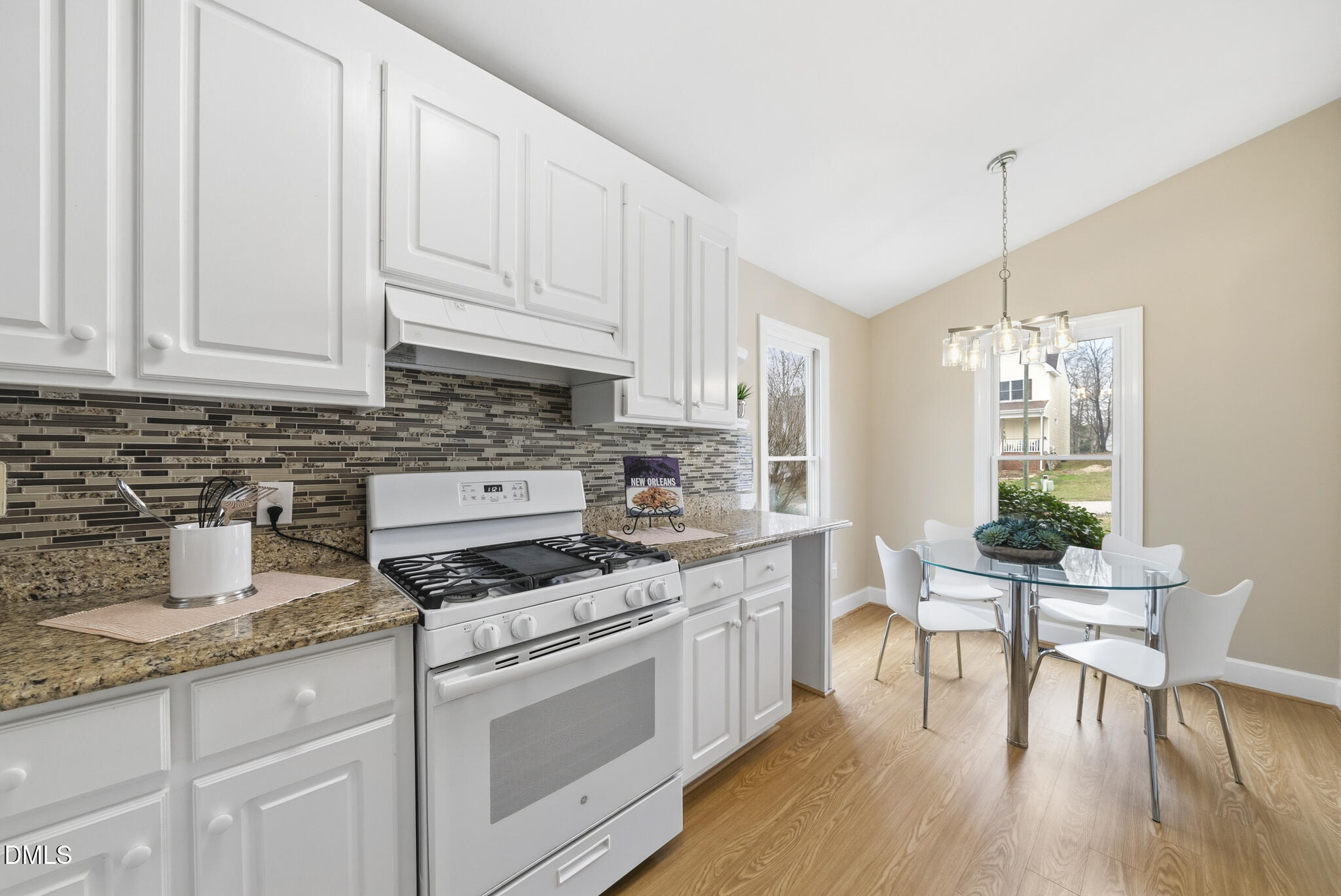 1944 Talamore Court Raleigh, NC 27604 - Photo 4 of 30 a kitchen with stainless steel appliances granite countertop a stove a sink dishwasher and white cabinets with wooden floor