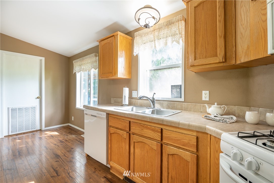 1735 Kaas Road Ferndale, WA 98248 - Photo 8 of 37 a kitchen with stainless steel appliances granite countertop a sink a stove cabinets and wooden floor