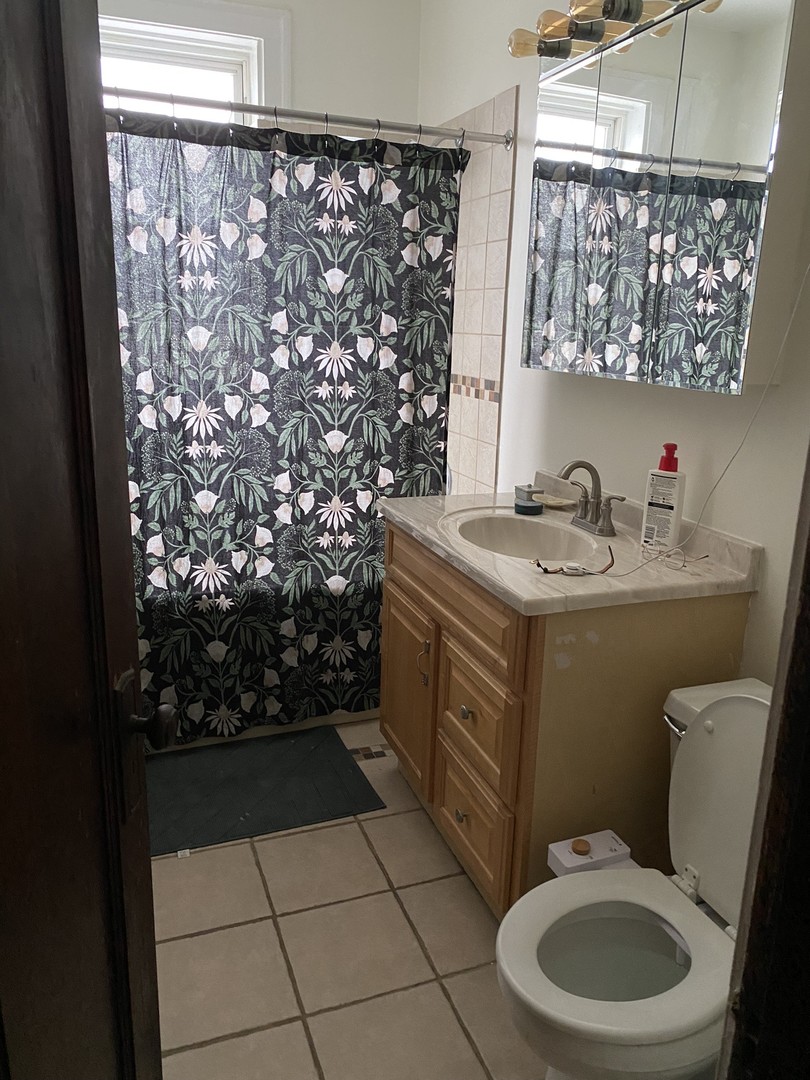 1408 West Warner Avenue, Unit 3W Chicago, IL 60613 - Photo 2 of 12 a bathroom with a toilet sink and mirror