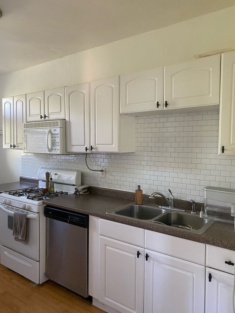 1408 West Warner Avenue, Unit 3W Chicago, IL 60613 - Photo 5 of 12 a kitchen with stainless steel appliances a sink a stove and cabinets