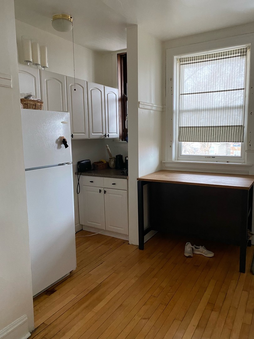 1408 West Warner Avenue, Unit 3W Chicago, IL 60613 - Photo 6 of 12 a kitchen with a refrigerator a sink and a window