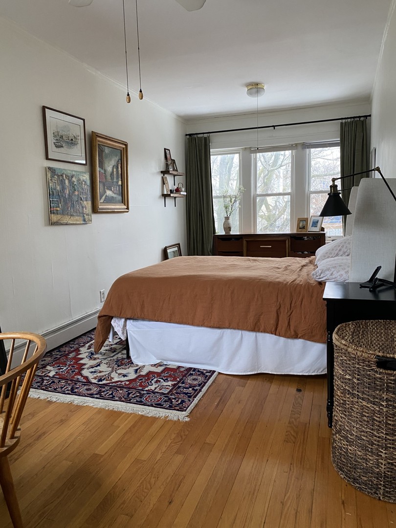 1408 West Warner Avenue, Unit 3W Chicago, IL 60613 - Photo 10 of 12 a bedroom with a bed and wooden floor