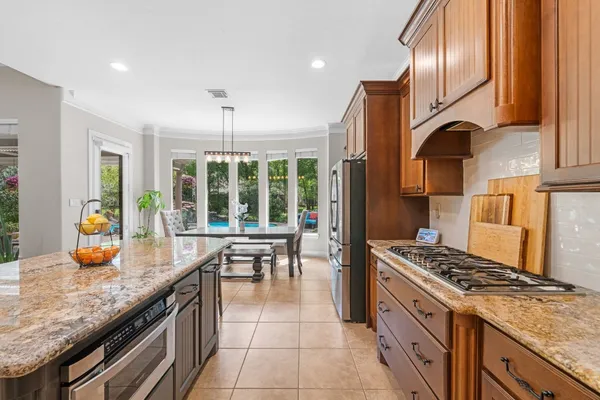 a kitchen with granite countertop wooden cabinets stainless steel appliances and a sink