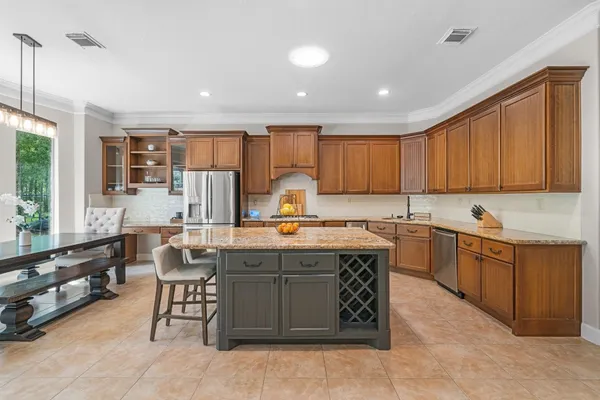 a kitchen with kitchen island granite countertop wooden cabinets a center island and appliances