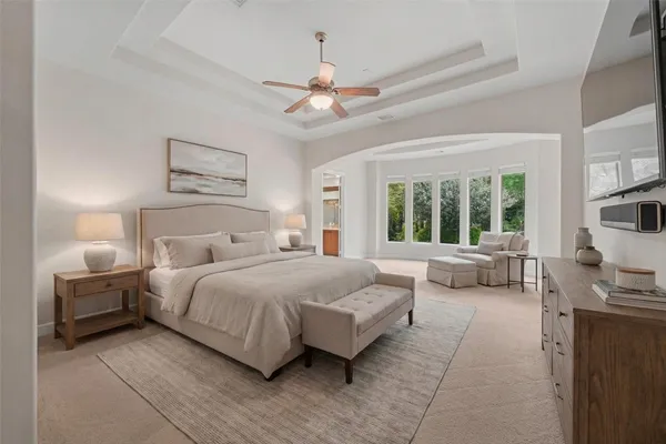 a bedroom with a large bed and a chandelier