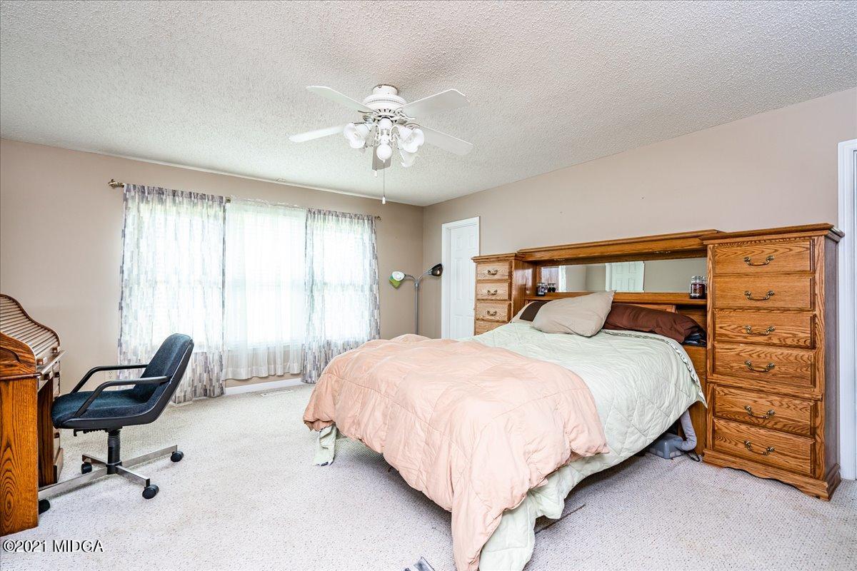 2696 Lower Hartley Bridge Road Byron, GA 31008 - Photo 13 of 24 a bedroom with a bed and a chandelier