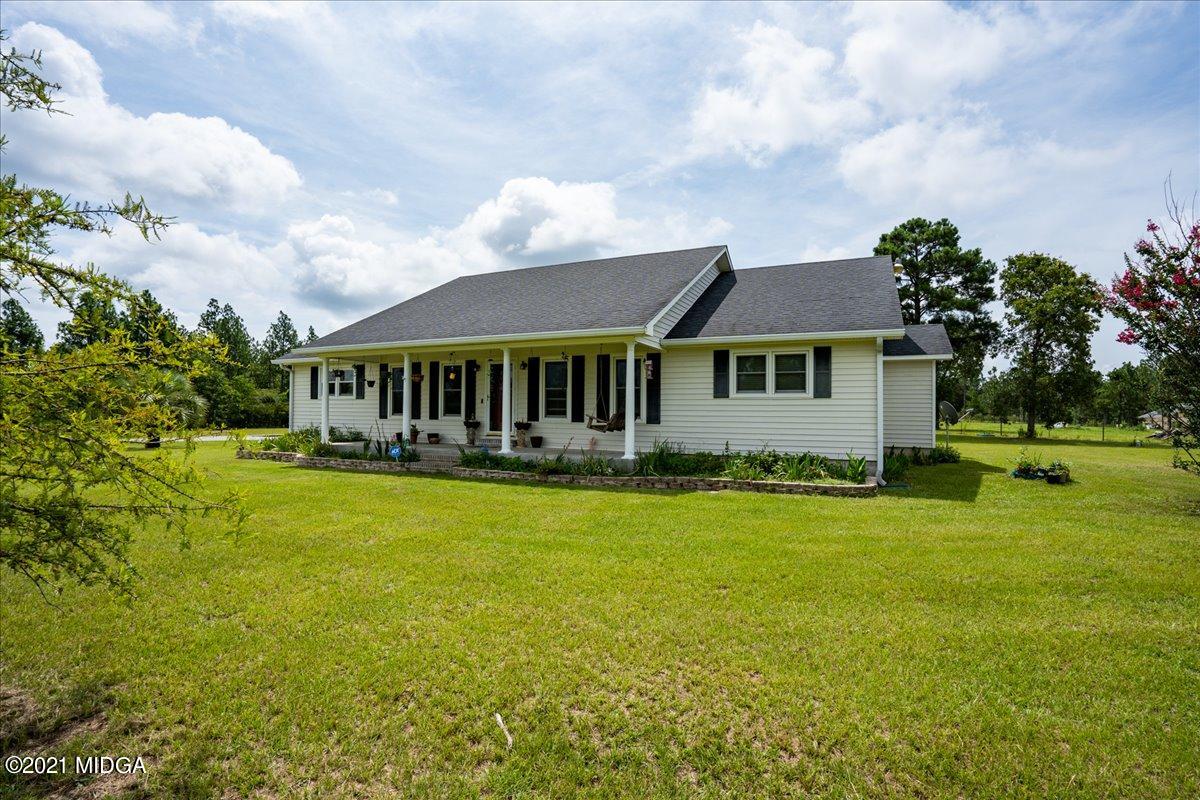 2696 Lower Hartley Bridge Road Byron, GA 31008 - Photo 3 of 24 a view of a house with a big yard and large trees