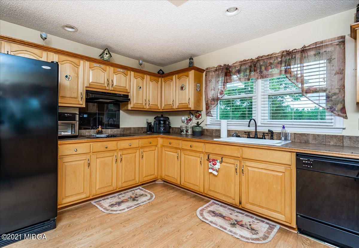 2696 Lower Hartley Bridge Road Byron, GA 31008 - Photo 21 of 24 a kitchen with stainless steel appliances granite countertop a sink and cabinets