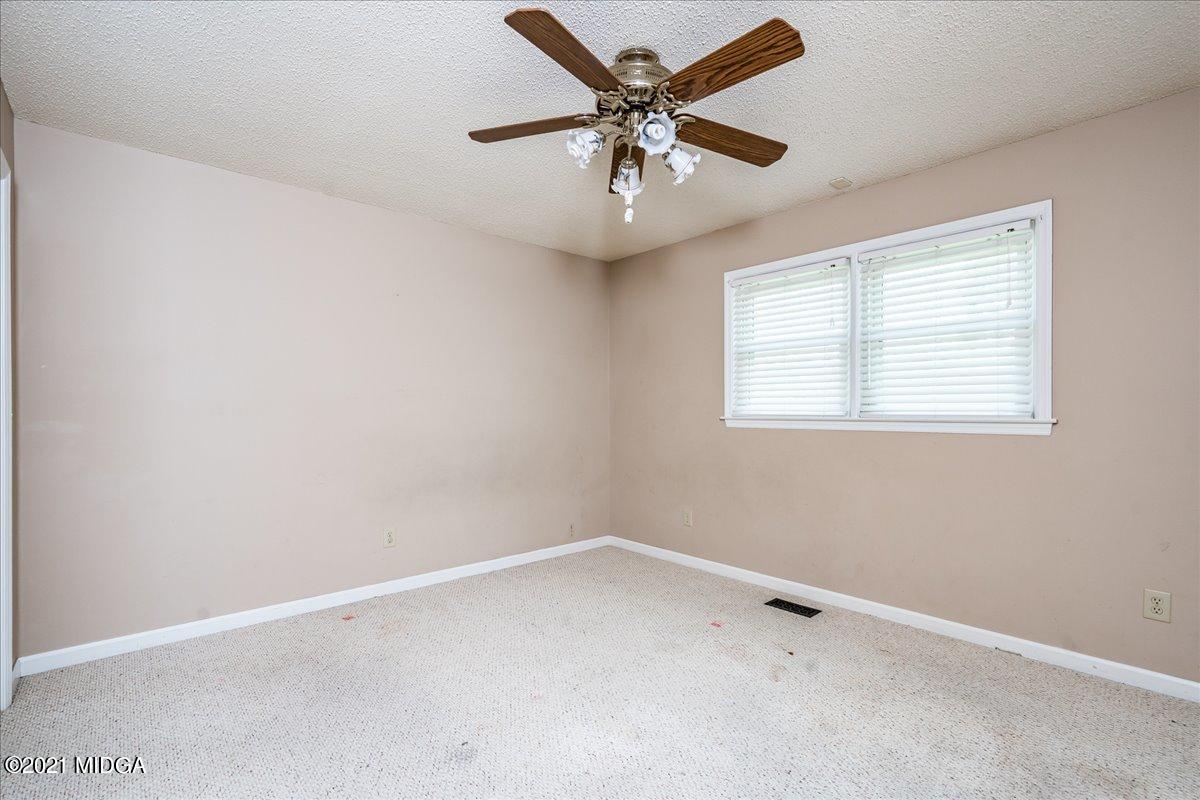 2696 Lower Hartley Bridge Road Byron, GA 31008 - Photo 9 of 24 an empty room with a window and a fan