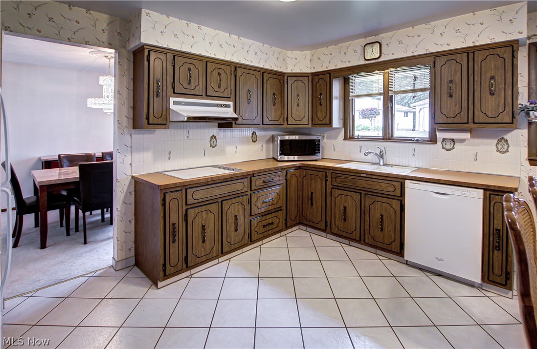 6013 Rousseau Drive Parma, OH 44129 - Photo 3 of 50 Kitchen with black electric stovetop, light carpet, backsplash, sink, and dishwasher