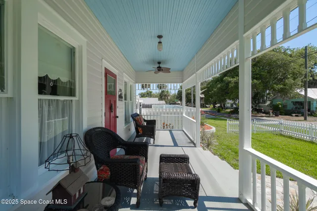 a view of a backyard with table and chairs and potted plants with wooden fence