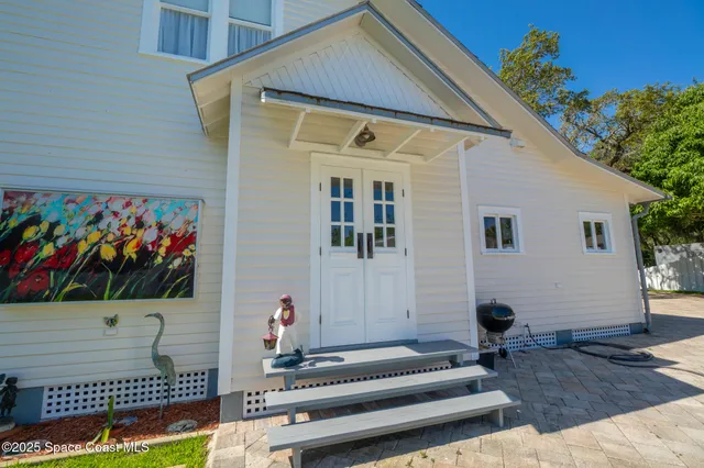 a view of a roof deck with table and chairs a barbeque with wooden floor and fence