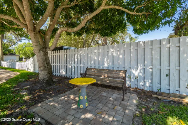 a living room with patio furniture and a chandelier