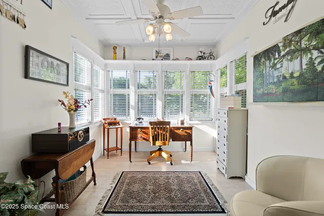a view of a hallway to a livingroom with furniture and window