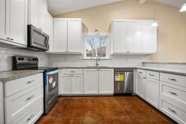 a kitchen with stainless steel appliances granite countertop a sink and a stove