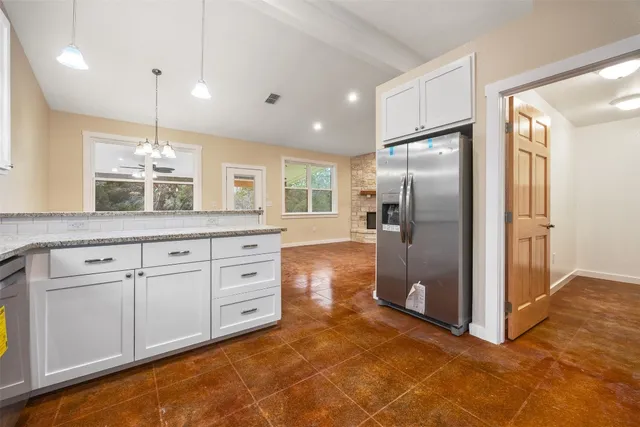 a kitchen with kitchen island granite countertop cabinets and refrigerator