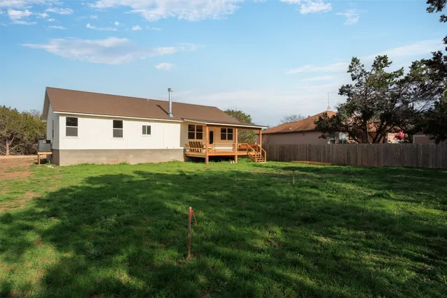 a front view of house with yard and trees in the background